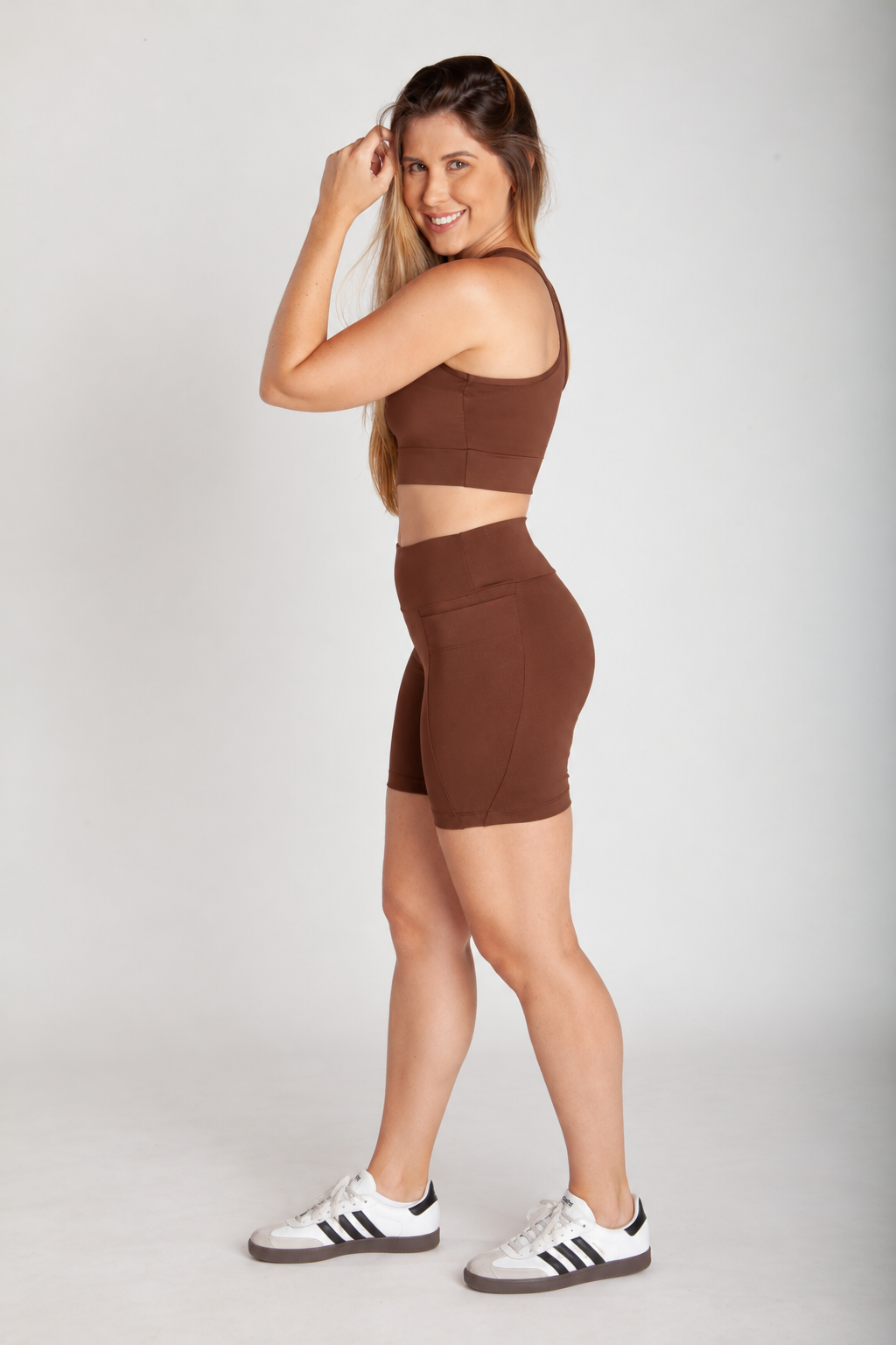 Bermuda fitness feminina cappuccino com bolsos laterais vista lateral corpo inteiro