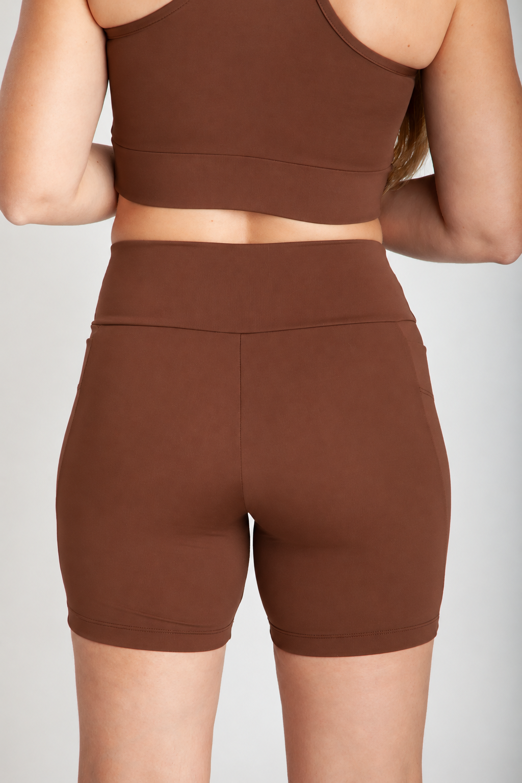 Bermuda fitness feminina cappuccino com bolsos laterais vista costas