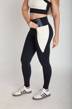 Legging fitness feminina preta e off white com bolsos laterais em Nagoya detalhe do bolso lateral com celular