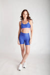 Top fitness feminino bicolor em Wonder azul índico com rosa callas vista frontal corpo inteiro
